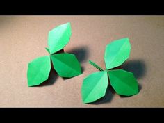 three green paper flowers sitting on top of a table