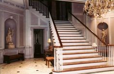 an elegant staircase with chandelier and marble flooring