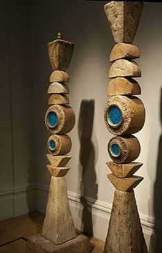 three tall wooden sculptures sitting on top of a hard wood floor