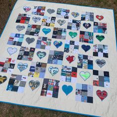 a quilt made with many different patches and heart shaped stickers on the back of it