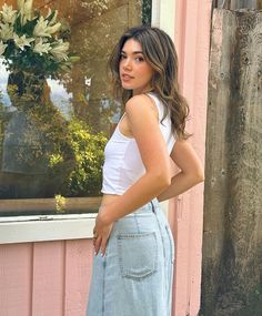 a woman standing in front of a window with her hands on her hips and looking at the camera