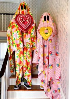 two towels are hanging on the stairs in front of a wall with hearts and flowers