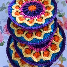 four crocheted bowls are stacked on top of each other