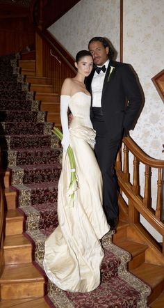 a man in a tuxedo standing next to a woman in a wedding dress