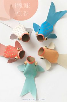 four fish made out of toilet paper on top of a white surface with the words paper tube koi fish