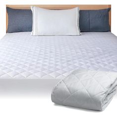 a bed with white sheets and pillows on top of it next to a blue pillow