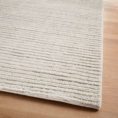 a beige rug on top of a wooden floor