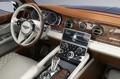 the interior of a luxury car with leather and wood trims, including steering wheel