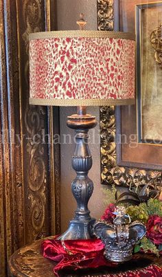 a lamp that is sitting on a table next to a vase with flowers in it