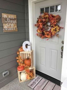 the front door is decorated with fall leaves, pumpkins and an autumn wreath on it