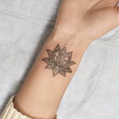 a woman's arm with a tattoo on it that has a flower in the middle