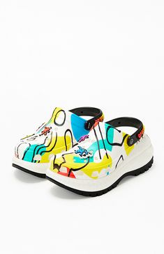 Elevate your style with the Keith Haring Mega Crush Clogs from Crocs, featuring vibrant Keith Haring graphics and an iconic heart-detailed back heel strap for a pop of artistic flair. With the Keith Haring name proudly displayed on the heel, custom jibbitz charms, and a platform heel, these clogs are a bold statement piece for those who love to stand out with every step.

PLEASE NOTE: This shoe is offered in men's sizes; please consult the Size Guide above - the conversion is two sizes smaller f Pacsun, Custom Jibbitz, Platform Heels Chunky, Keith Haring, Platform Heel, Chunky Platform, Womens Clogs, Platform Heels, Strap Heels