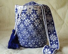 a blue and white bag sitting on top of a bed