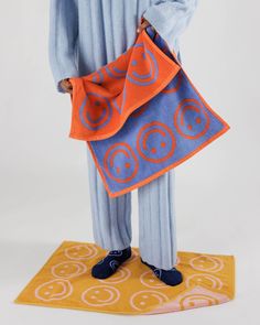 a man in blue and orange is holding an orange and blue bag with circles on it