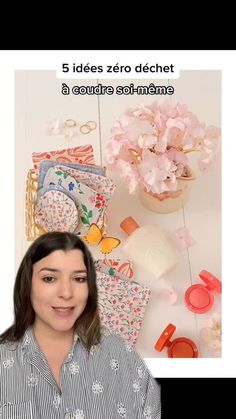 a woman standing in front of a table filled with items