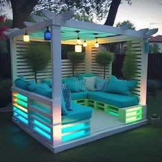 an outdoor living area is lit up with blue and green lighting, including a couch