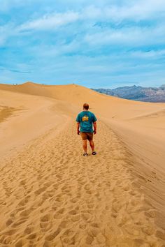 a man is walking in the sand dunes