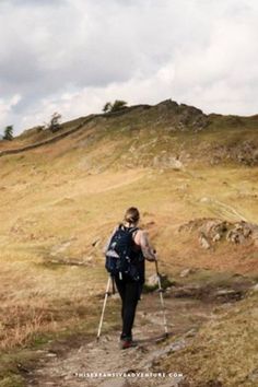 a woman walking up a hill on crutches