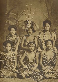 an old black and white photo of women in native american dress with headdress