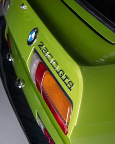 the rear end of a lime green bmw car with chrome lettering on it's license plate