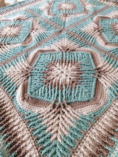 a crocheted blanket that is on top of a table