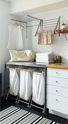 an organized laundry room with clothes hanging on the rack