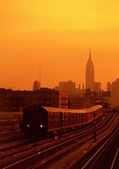 a train traveling down tracks next to tall buildings