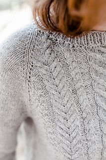 the back of a woman's sweater that has been knitted in two rows