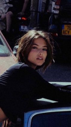 a woman sitting on the hood of a car