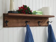 towel hooks are hanging on a wooden shelf