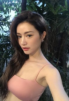 a woman in a pink top posing for the camera