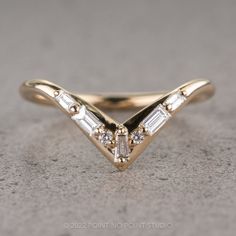 a yellow gold ring with three baguettes on the side and two diamonds in the middle