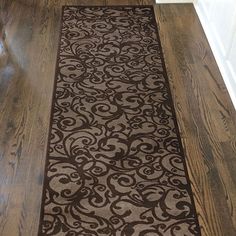 a brown and white rug is on the floor next to a wooden door in a house