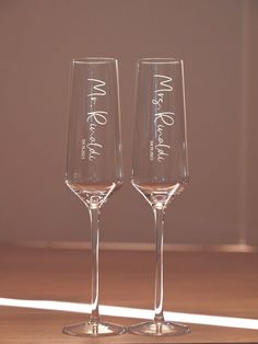 two wine glasses sitting on top of a wooden table