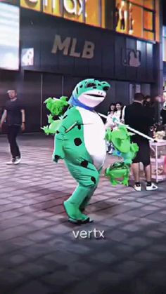 a person in a costume standing on a brick sidewalk with other people walking around behind him