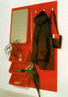 a red coat rack with mirror, umbrella and potted plant