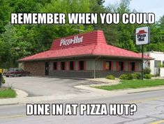 a pizza hut sitting on the side of a road next to a street sign that says, remember when you could dine in at pizza hut?