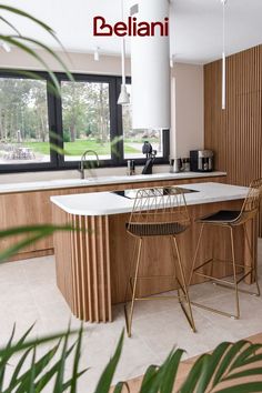 a modern kitchen with an island and bar stools in the center, surrounded by wood paneling