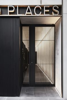 an entrance to a building with black doors and the word no places on it's side