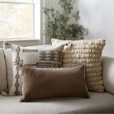 the pillows on the couch are all different shapes and sizes, but one is brown