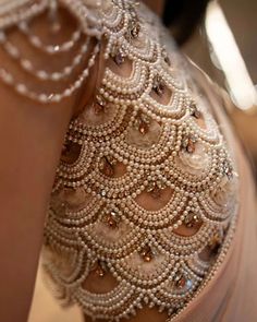 the back of a woman's dress with pearls on it