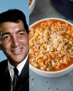 a man in a suit and tie next to a bowl of pasta with cheese on top
