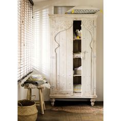 an old white armoire in the corner of a room