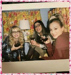 three women are holding wine glasses and posing for the camera