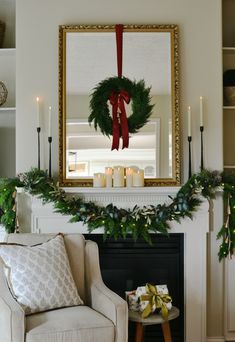 a living room decorated for christmas with wreaths and candles