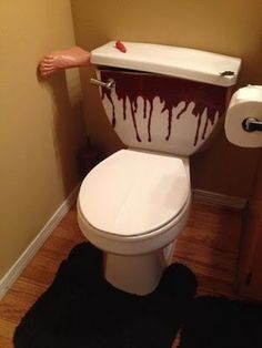 a white toilet with red paint on it in a bathroom