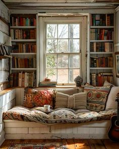 a window seat in front of a bookshelf filled with books