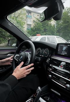 a person driving a bmw car on a city street