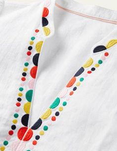 a white shirt with multicolored polka dots on it