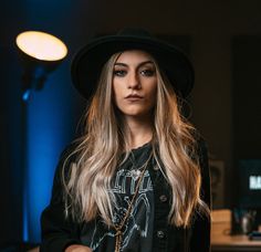 a woman with long hair wearing a black hat